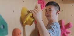 Junge bouldert mit Spass die Wand hoch
