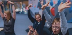 2 Kinder und 2 Betreuer reißen die Arme nach oben