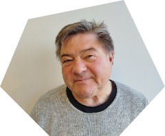 Lächelnder Mann um die 70 mit kurzem, grauen Haar und glattrasiert