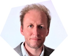 Lächelnder Mann mittleren Alters mit kurzem blonden Haar und Bart