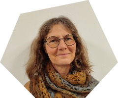 Lächelnde Frau mittleren Alters und Brille mit leichtergrautem, blondbraunem gewelltem Haar