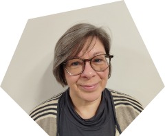 Lächelnde Frau um die 60 mit grauem Haar zum Bob geschnitten und Brille